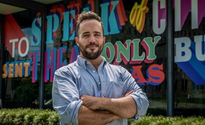 Brisbane artist Sam Cranstoun in front of his commissioned work wrapped around the UQ Art Museum at St Lucia